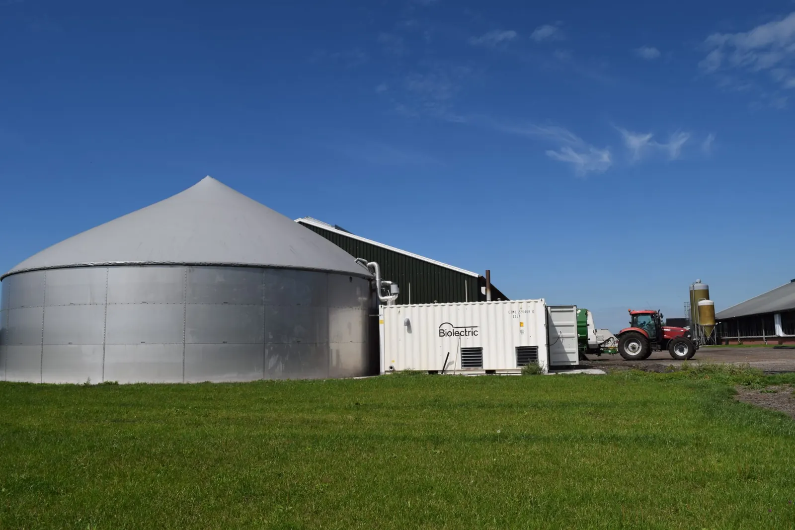 Biolectric container and digester next to farm buildings