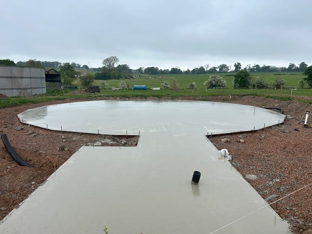 A completed circular concrete pad, poured and ready for plant installation