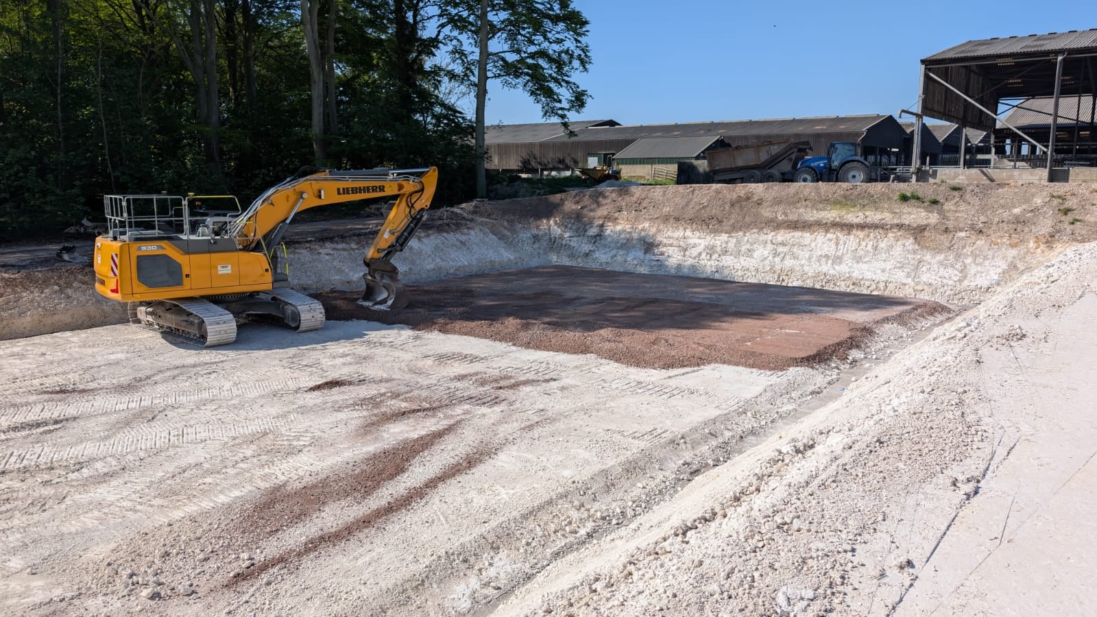 An excavator working a hardcore base during groundworks