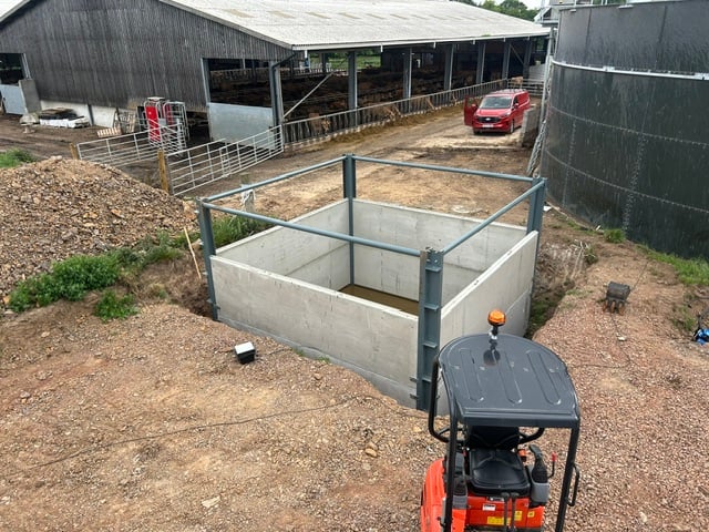 A farm building and cattle yard alongside an installation site