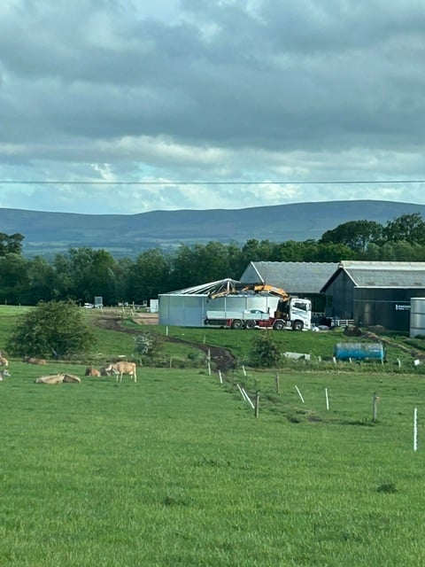 A working farm's fields and buildings, seen from an installation site