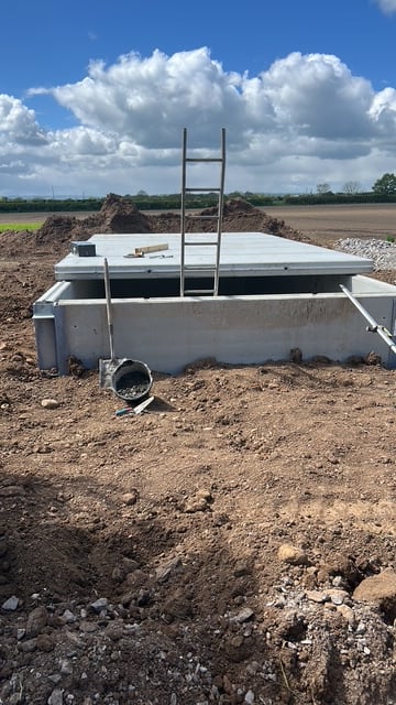 A digester tank wall under construction, with an access ladder in place